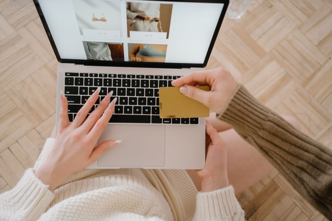 services-03 Personne faisant des achats en ligne sur un ordinateur portable avec une carte bancaire, mettant en avant la facilité du e-commerce.